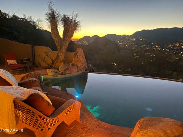 Experience luxury living with this hillside infinity-edge pool, perfectly positioned to capture the breathtaking Arizona sunsets and sparkling city lights beyond the rugged mountains of Paradise Valley.