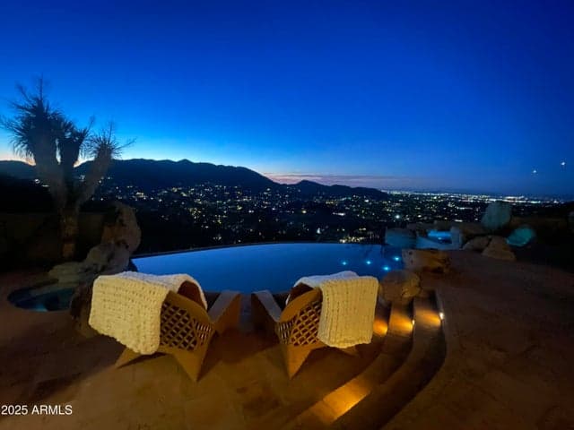 The magic of desert evenings comes to life with this breathtaking twilight scene. Enjoy resort-style living with ambient lighting, a tranquil spa, and an infinity pool that appears to merge with the horizon. The northwest-facing orientation delivers spectacular views of city lights and mountain silhouettes.