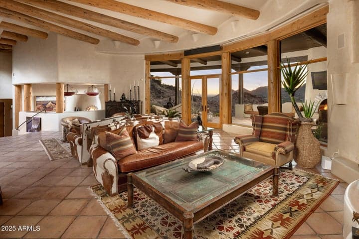 Floor-to-ceiling windows flood this stunning great room with natural light, revealing expansive Paradise Valley and mountain vistas. The open living space flows seamlessly into the outdoors for effortless entertaining and year-round enjoyment.