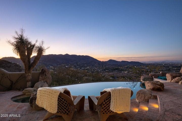 Take in sweeping panoramic views of Paradise Valley from this elegant infinity-edge pool overlooking the mountains. This elevated outdoor space captures stunning sunset vistas to the northeast and showcases the serene ambiance of luxury desert living. Featuring natural stonework and custom lighting, it’s the perfect setting to unwind and entertain.