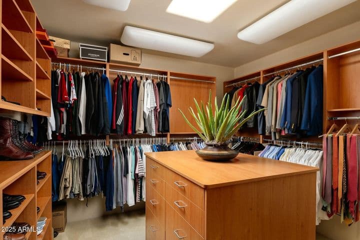 Enjoy abundant storage with two expansive walk-in closets in the primary suite. Custom cabinetry, built-in drawers, and overhead lighting offer both luxury and functionality in this thoughtfully designed dressing space.