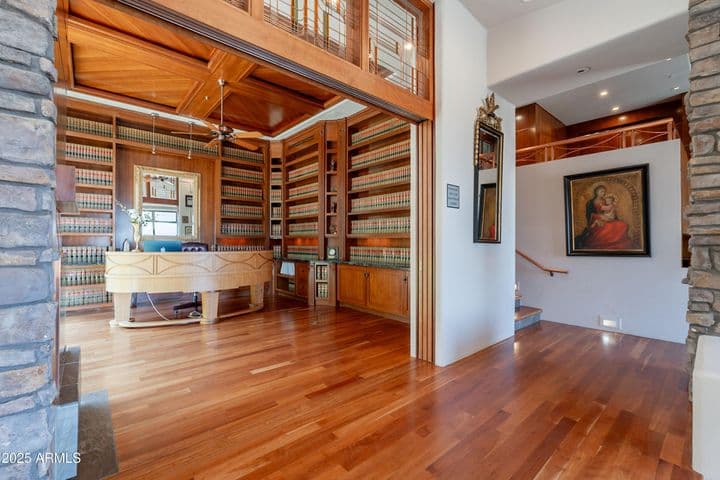Behind those stunning doors is a C-suite office with rich mahogany library shelving and coffered ceiling