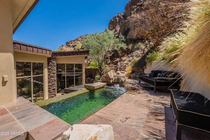 Floor-to-ceiling window gives you a direct valley-wide view through the home as you soak in the infinity spool