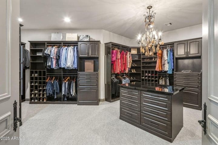 Boutique-style walk-in closet with custom niches and private washer and dryer