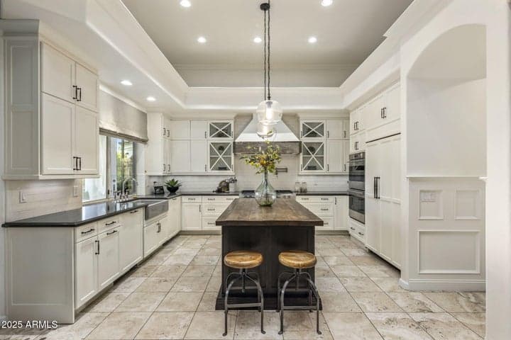Custom Sub-Zero fridge, Wolf appliances, Butcher Block island, barn wood accents, and Windsor-style glass cabinetry