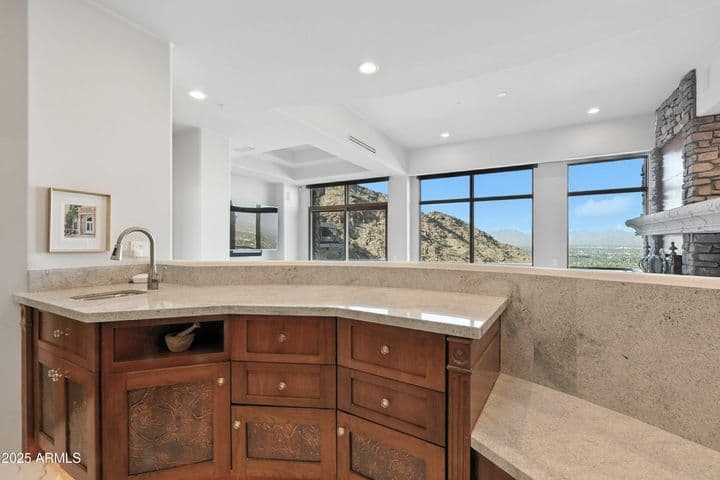 Open to the family room with floor-to-ceiling windows to capture the Valley-wide views